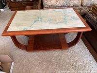 Full view of rectangular wooden coffee table with glass top and nautical chart visible underneath