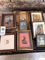 Overall view of 9 vintage portrait pictures with varying frames and sizes laid out on a rug.