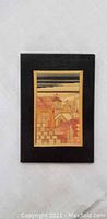 Front view of handcrafted wooden church picture on black frame.
