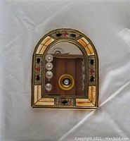 Front view of the Moroccan arched mirror showing the gold-tone metal frame with natural inlay and colored stones.