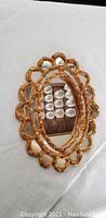 Full view of the oval mirror showing the golden wood frame and reflective glass surface.