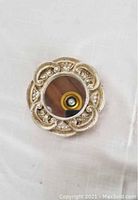 Top view of round ceramic silver glazed mirror showing ornate scroll and leaf details on the frame with convex glass mirror center.
