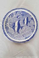 Full view of the ceramic plate laid flat, showing the entire blue coral reef design with fish on white background.