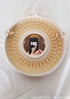 Front view showing the round design, intricate lattice clay pattern, curled edges, and centered mirror.