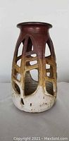 Front view of the ceramic candle holder showcasing glaze colors and open cut-out design.