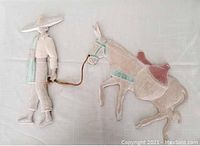 Cast iron wall art showing man and donkey from a front angle.