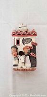 Front view of the clay figurine showing the Indigenous family and home