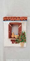 Front view of the white window wall decor with red roof tiles, two terracotta clay jars and potted plant on the window sill