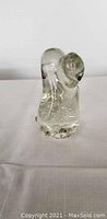 Front view of a clear glass dog figurine with visible bubble inclusions and rounded shaping of the head and body.