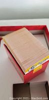 Photo of the game box with stacked cards inside viewed from above.