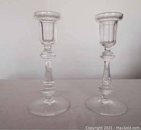 Two clear glass Waterford candlesticks standing side by side, showing full front view with measurement implied by relative scale.