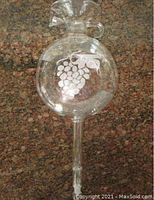 Full view of the crystal wine aerator with grape etching on a granite countertop.