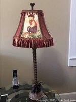 Front view of the Bombay table lamp showing monkey base and detailed fabric lampshade with fringe.