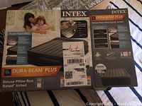 Boxed Intex Dura-Beam Plus Deluxe Pillow Rest Raised Airbed Queen Size with product features and measurements visible on packaging.