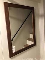 Front view of the wood framed rectangular mirror, showing the wood grain frame and reflective surface.