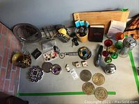 Assortment of bar and kitchen items including cutting board, leopard print pitcher, bar tools, glass cordial glasses, marble napkin holder and metal accessories.