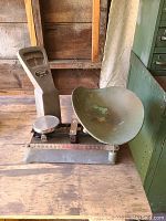 Full view of the vintage metal scale showing base, dial, weighing pan, and ruler scale on base.