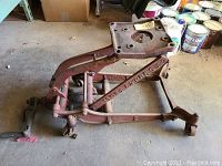 Side view showing the metal frame, crank handle, and wheels of the antique lift.