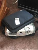 Front angle view of Epson projector with remote and carrying case placed on top.