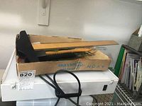 Electronic light box underneath drafting tools and box containing rulers and protractor