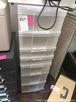 Front view of tall vertical unit of 7 semi-transparent plastic drawers stacked.