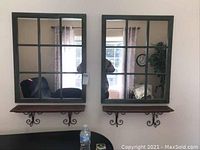 Two windowpane style mirrors hung side by side with wooden shelves below, on a light colored wall