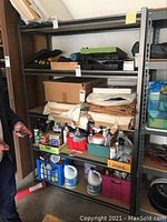 Photo showing full shelving unit loaded with various items, illustrating storage capacity and condition.