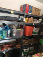 View of two metal shelves filled with various storage containers and boxes showing the structure and size of shelves.