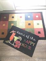 Photo of two outdoor rugs, one with geometric squares and one with cocktail graphic