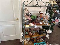Full view of bakers rack showing three shelves filled with various decorative items but focusing on structure of rack.