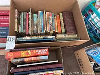 Photo of one box filled with mostly children's books with visible titles and varied colors.