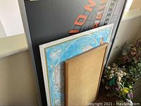 Three wall art pieces stacked together including a framed bulletin board on a map, a Union Station travel poster, and a horse painting.