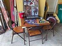 Image showing card table and four chairs with sports memorabilia on table.