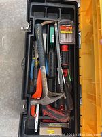 Top view of toolbox with hammer, saws, screwdrivers, files, and drill bits inside
