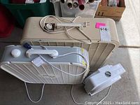 Three fans including a large beige Holmes box fan, a white square box fan, and a small white oscillating fan with power cords visible.