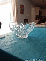 Side angle view of the clear crystal bowl showing floral and geometric cut patterns