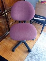 Front-facing view of mauve office chair showing padded seat and backrest with plastic base and wheels.