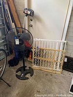 Hunter pedestal fan, white and wooden safety gates against door