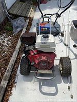 Front view showing the Honda GX engine, metal frame, wheels, and control panel.