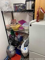 Black metal wire shelving unit shown with kitchen items and plastic containers, demonstrating shelving structure and approximate size.