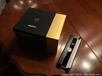 Photo showing unopened Wrapsody wireless headphones box and Mickey Mouse watch in its box placed on wooden table