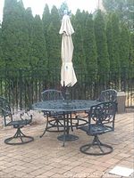 Full patio set with table, umbrella and four chairs on brick surface