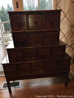 Front view of the stacked cubby cabinet showing three tiers with a total of 15 small drawers and round wooden drawer pulls.