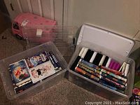 Two clear plastic storage totes containing multiple VHS movies with visible titles including Disney classics and other titles