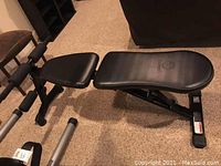 Full side view of the black vinyl padded adjustable sit up bench with metal frame.