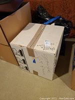 Closed cardboard box labeled as stained glass light fixture for packaging and storage.