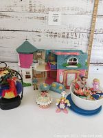 Foldable plastic playhouse with turret, furniture, and multiple vintage Cabbage Patch Kids figurines grouped around it.