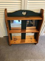 Photo of forest green trimmed wooden shelf with mirrors and heart cutout.