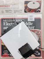 Dazey sandwich maker, electric appliance shown closed, white top with black latch, placed on its box.