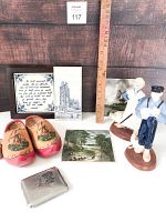 Photo showing the pair of wooden clogs, decorative plaques, figurines, and vintage smoking case arranged with measuring ruler.